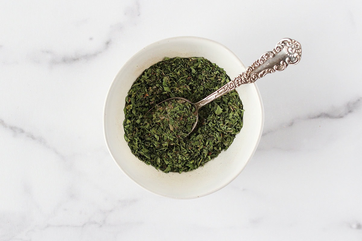 A spoon stirring together the ingredients for a homemade ranch seasoning mix.