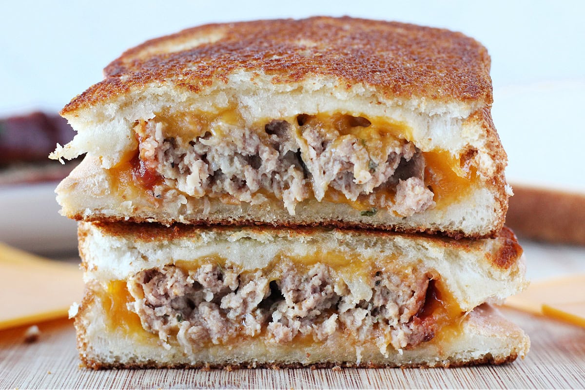 Grilled cheese with meatloaf in the middle cut in half and stacked.