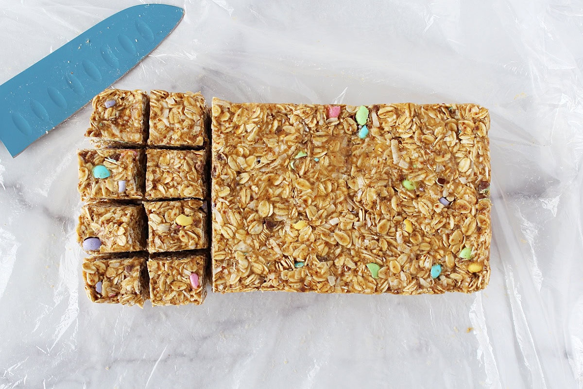 Easter M&M cookie bars cut into squares with a knife.
