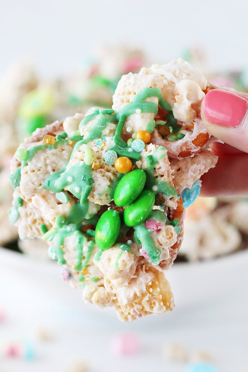 A hand holding a piece of leprechaun bait with St. Patrick's Day sprinkles and green M&Ms.