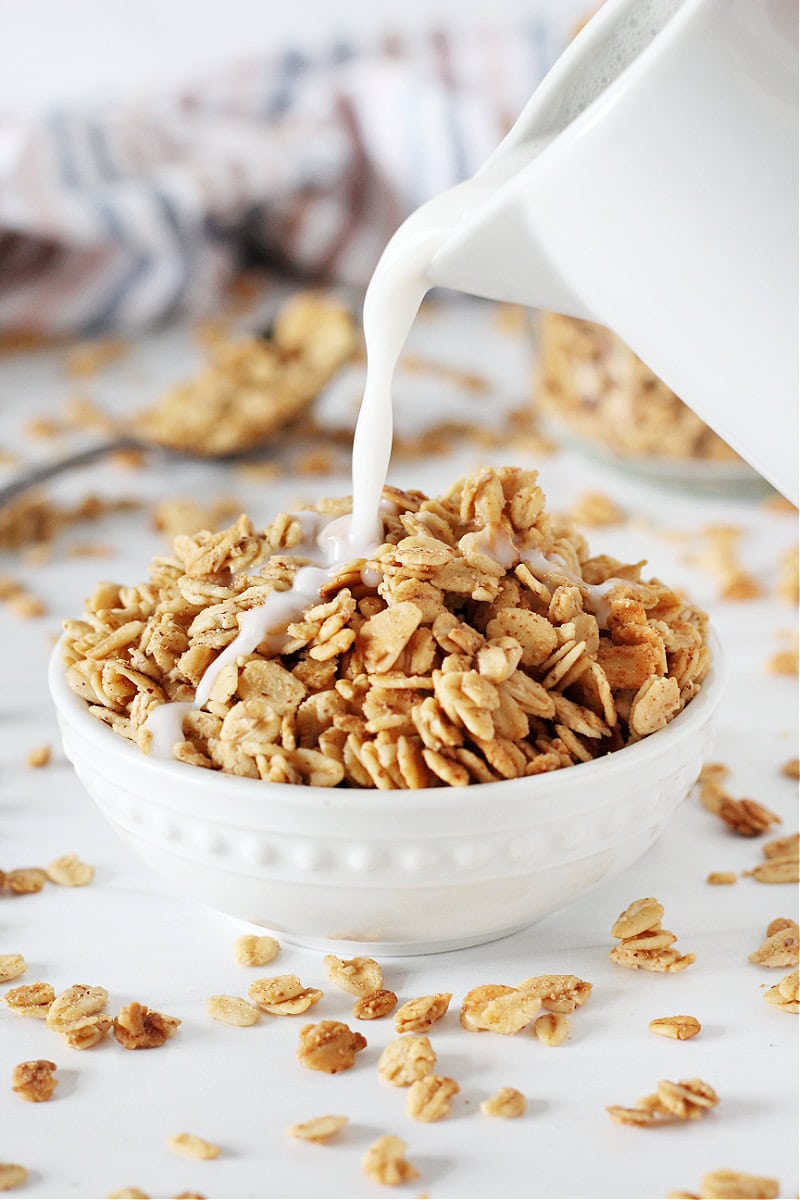 Milk being poured into a bowl of homemade French toast granola.