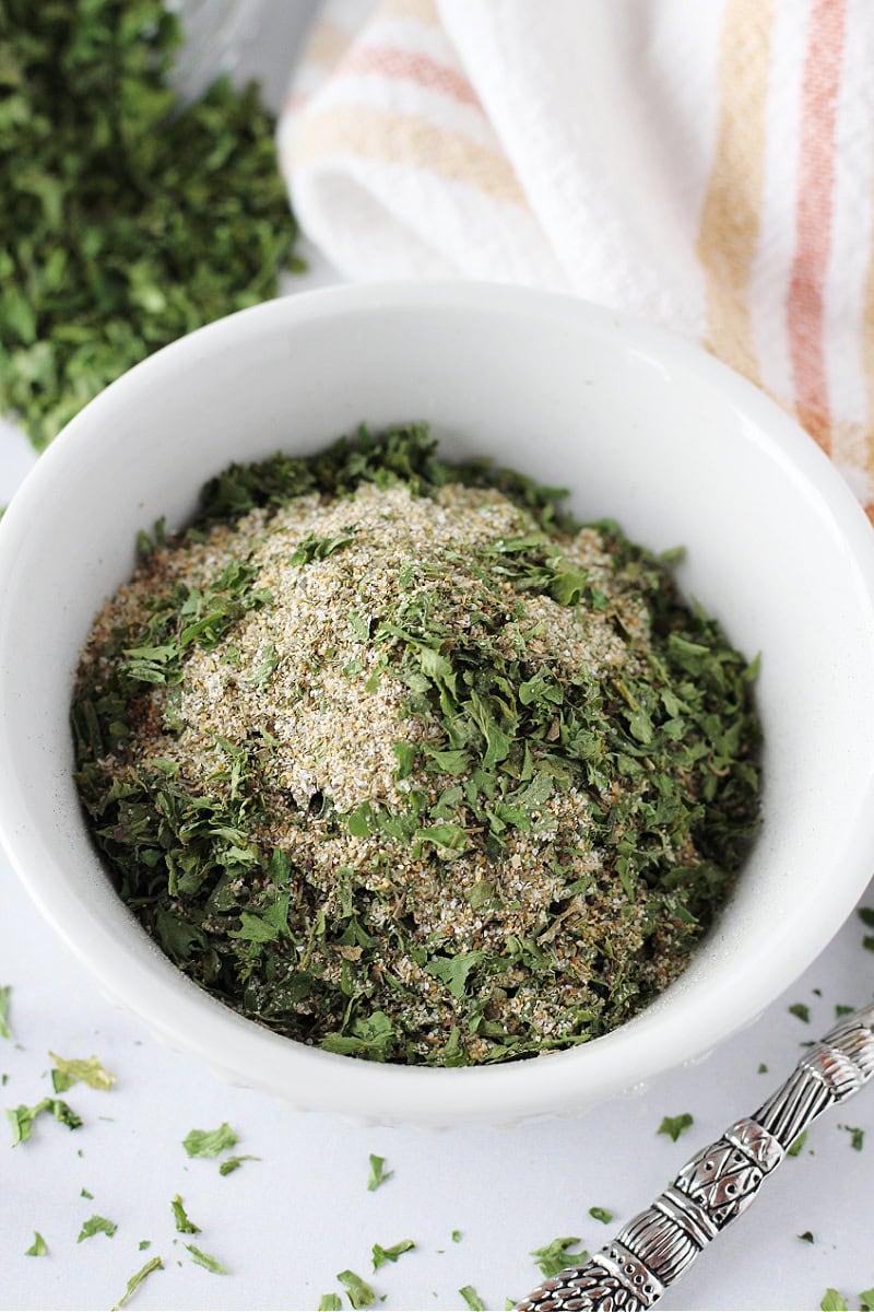 Homemade ranch seasoning mix with parsley and garlic powder in a white bowl.