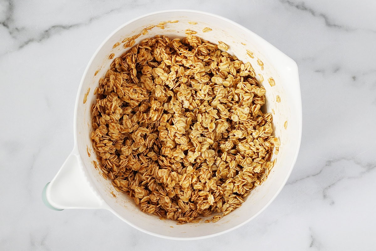 A white bowl with granola ingredients ready to be baked.