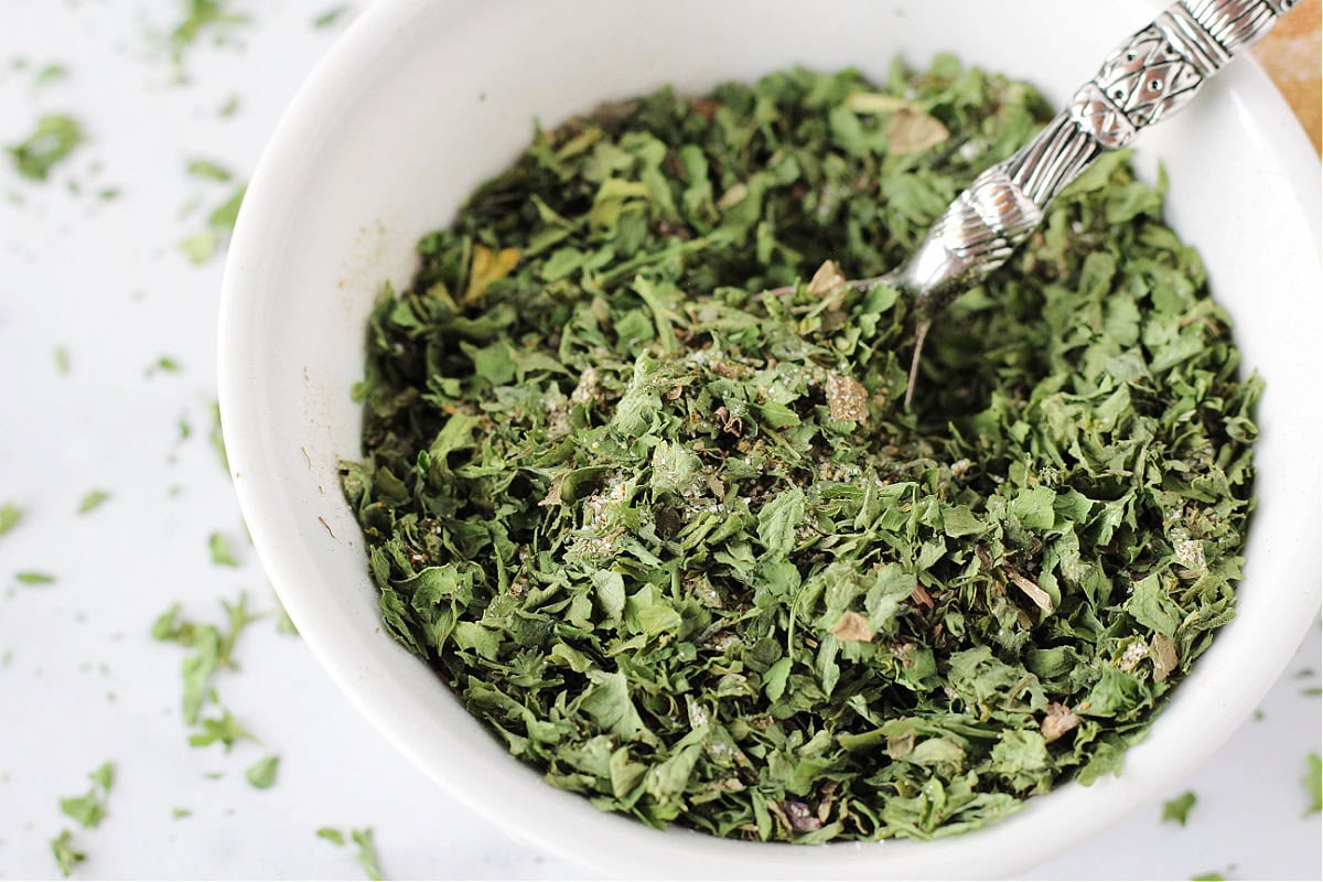 A spoon in a bowl of homemade low sodium ranch seasoning mix.