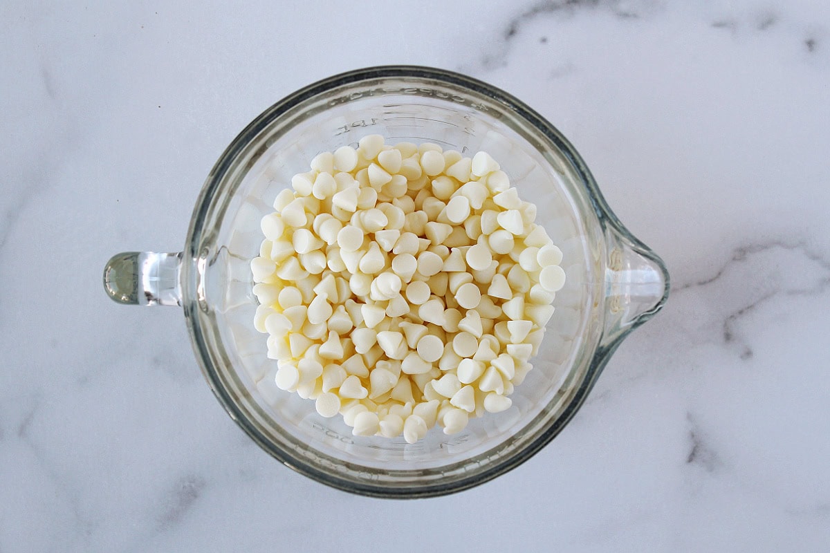 White chocolate chips in a glass measuring cup.