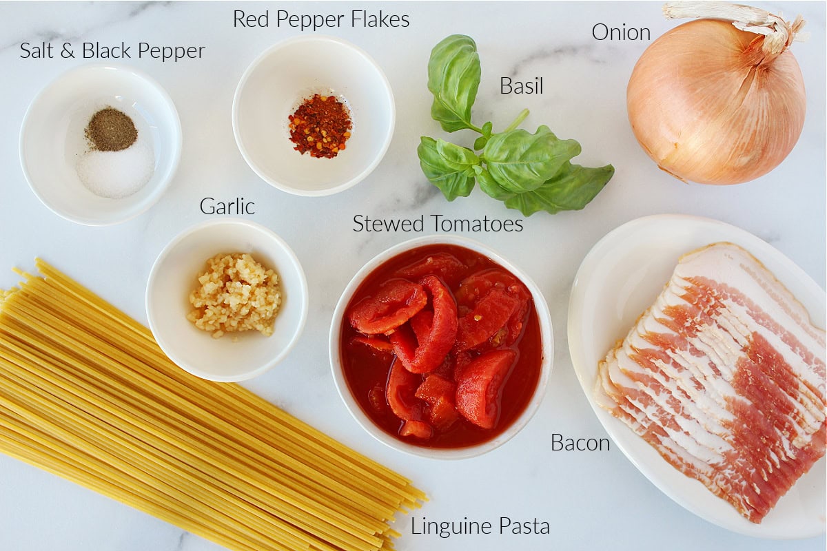 Labeled ingredients for Pasta All’Amatriciana on a white marble countertop.