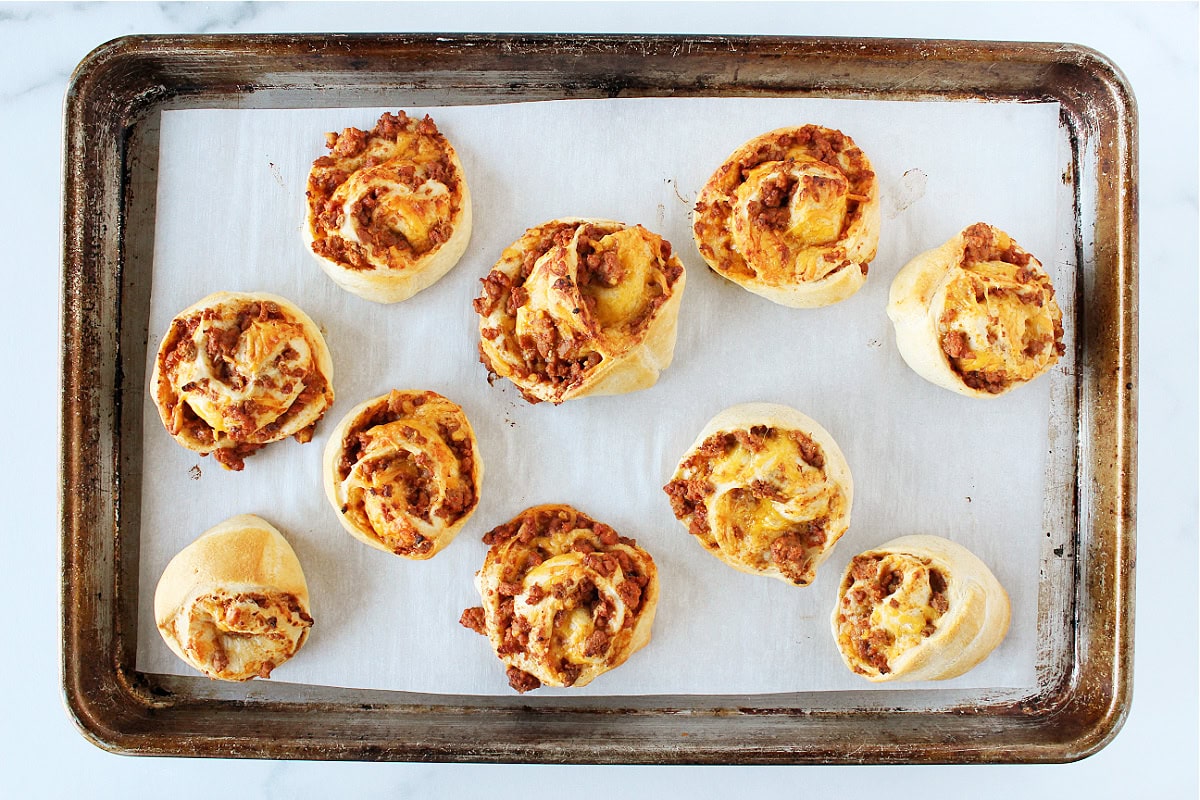 Ten golden brown baked sloppy joe crescent roll cups.