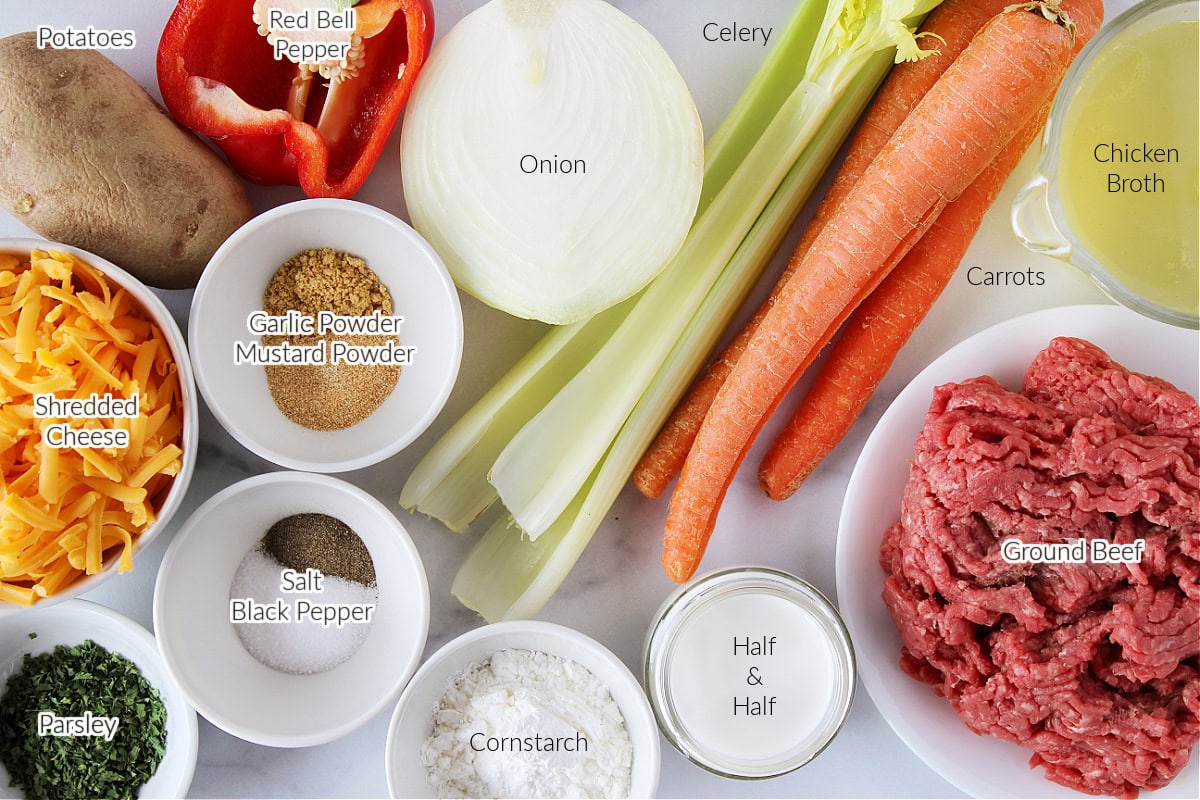 Labeled ingredients for easy cheeseburger soup on a white marble countertop.