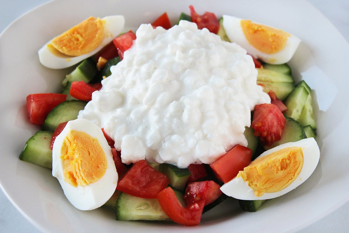 Cottage cheese on top of diced tomatoes and cucumbers with sliced hard boiled eggs.
