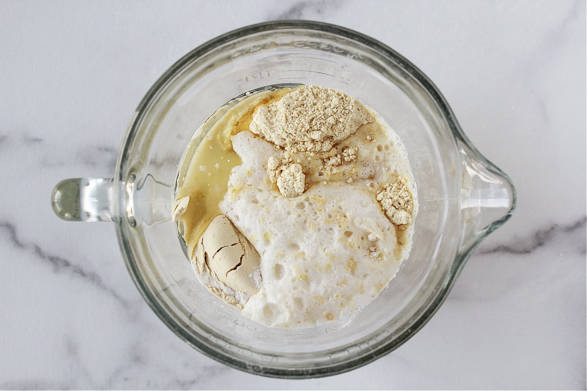 Vanilla protein powder, garbanzo bean flour and almond milk in a glass mixing bowl.