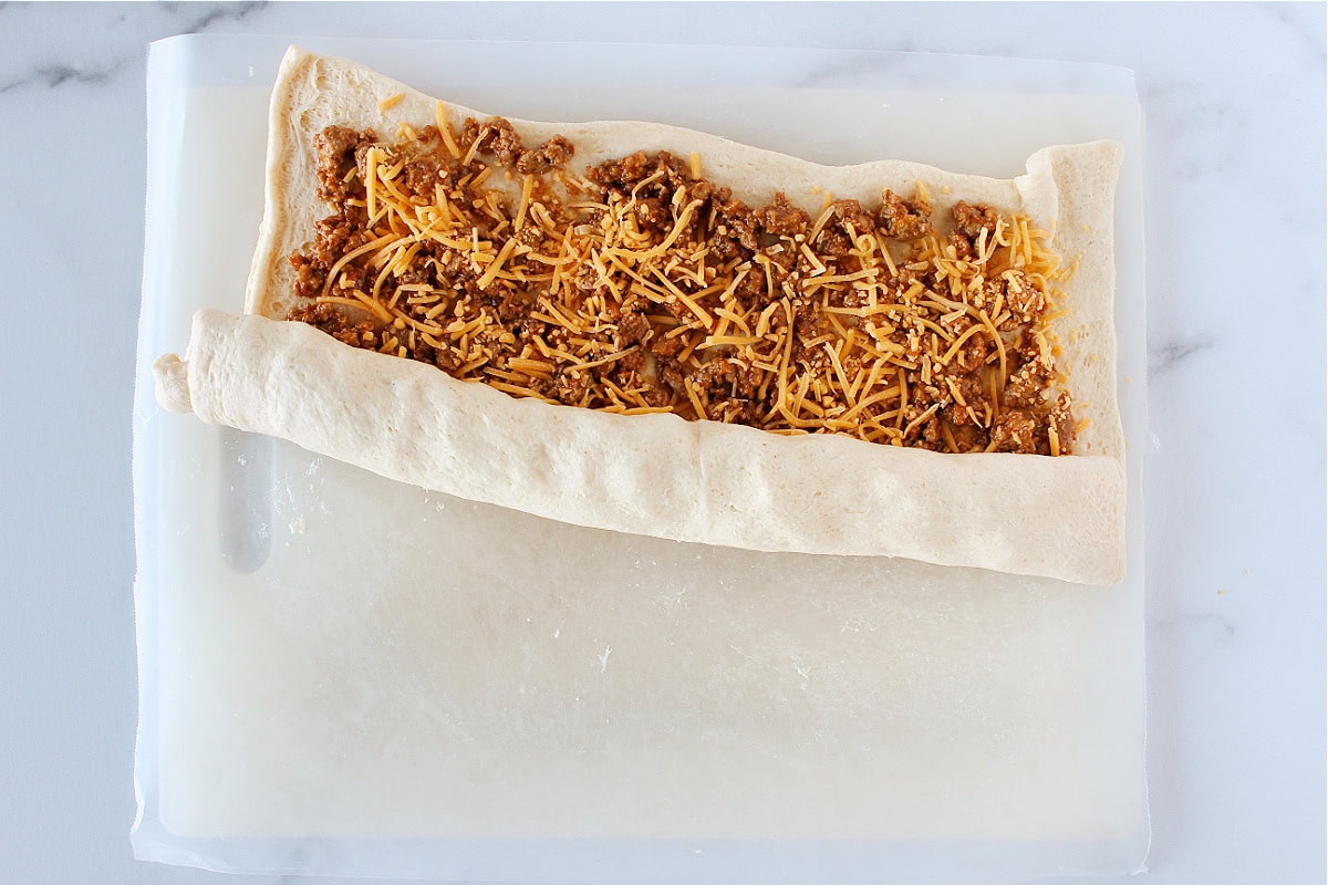 Sloppy joe mixture and shredded cheese rolled up in a crescent dough sheet.