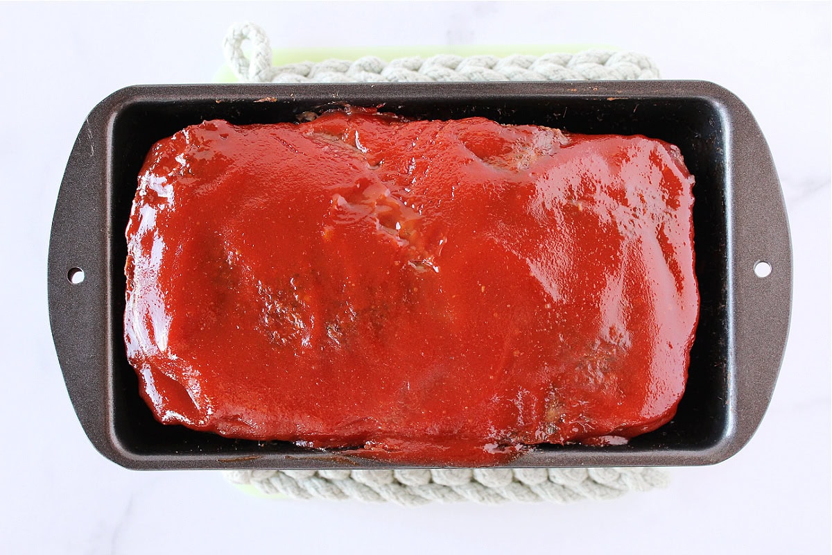 Baked glaze on whole foods meatloaf in a pan.