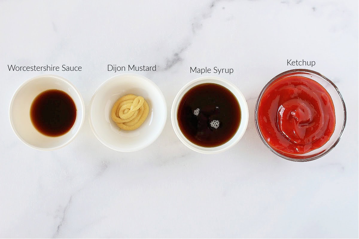 Four ingredients in small bowls for meatloaf glaze on a white marble countertop.