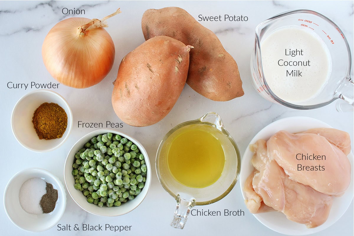 Labeled ingredients for chicken sweet potato curry on a white marble countertop.