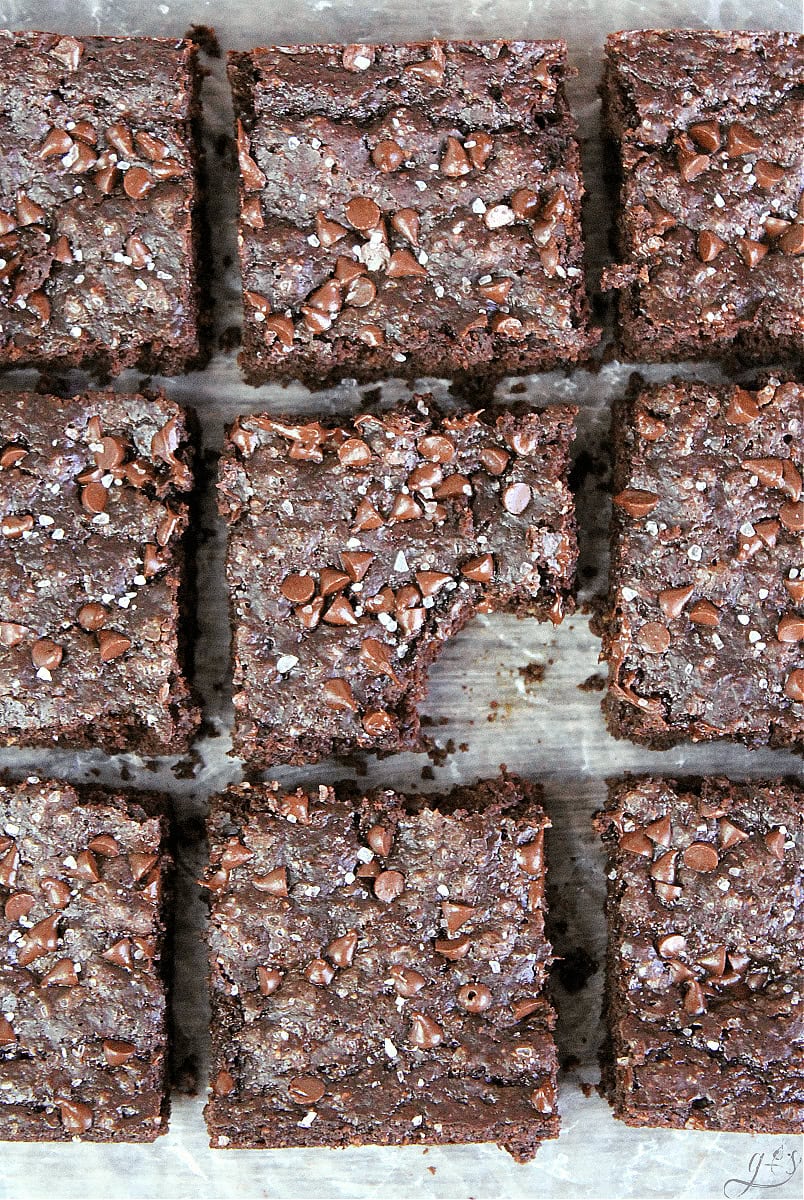 Nine sliced brownies with a bite taken out of the center brownie.