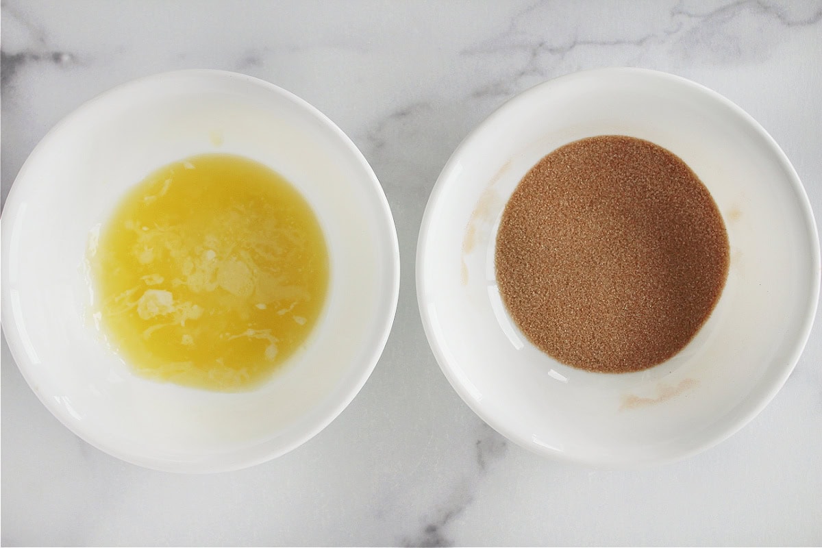 Melted butter and cinnamon sugar in two separate bowls.