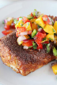 A blackened cod filet topped with a mango and red pepper salsa.