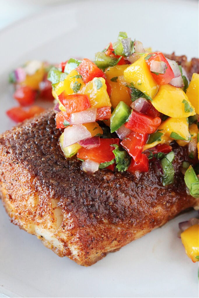 A blackened cod filet topped with a mango and red pepper salsa.
