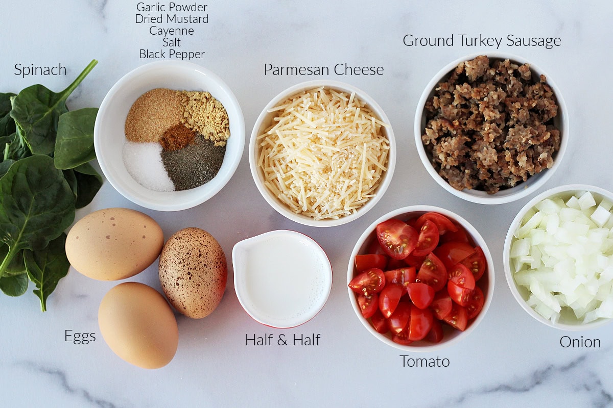 Labeled ingredients for a turkey sausage egg casserole on a white marble countertop.