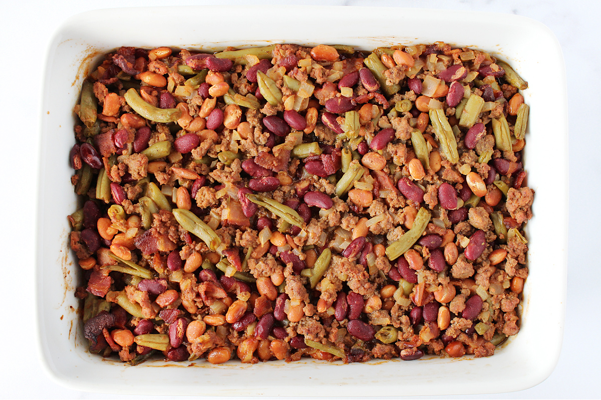 Calico beans baked in a 9x13 white baking dish.