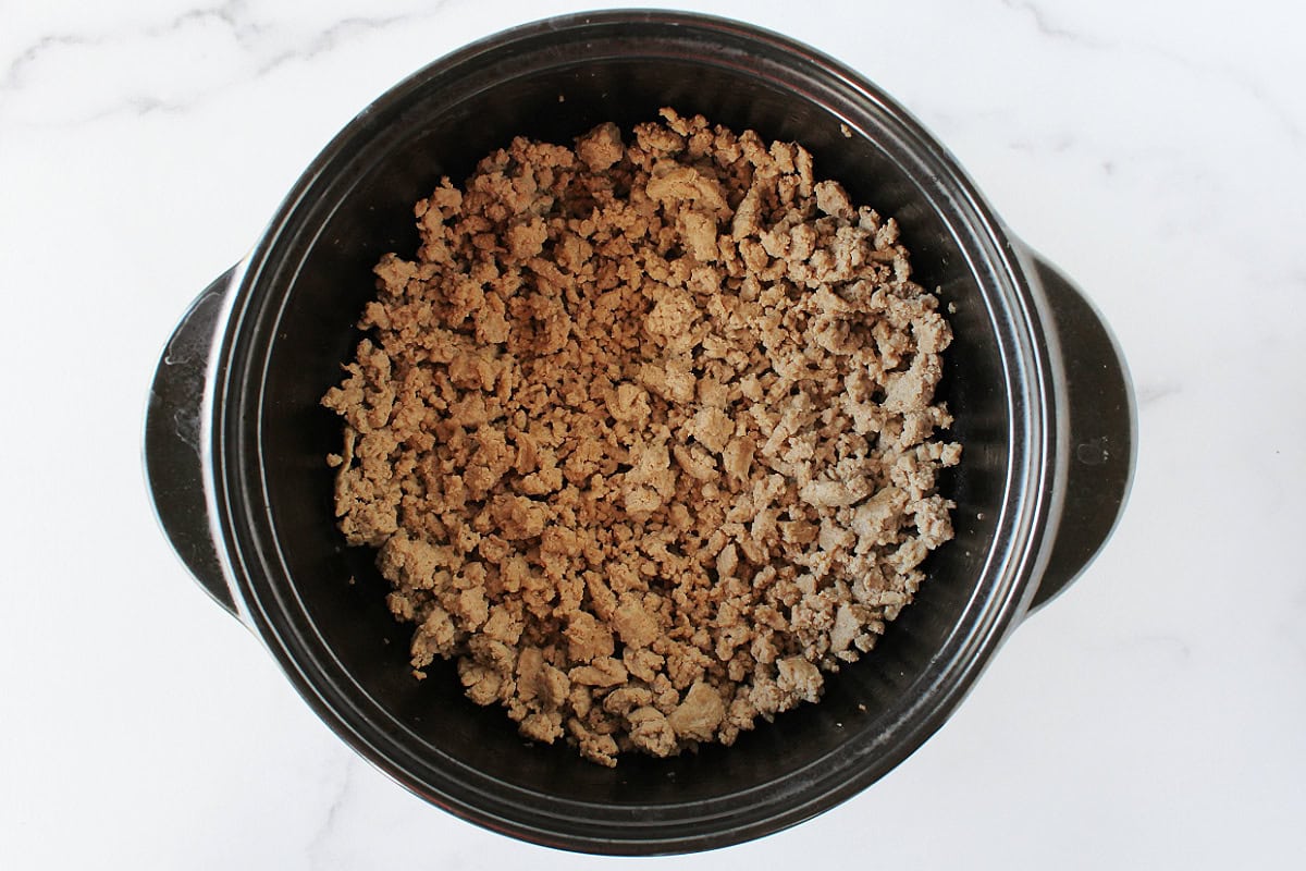 Browned ground meat in a black soup pot.