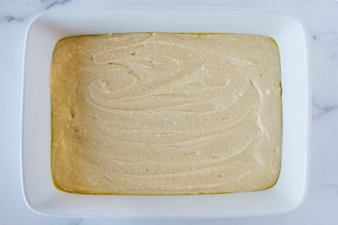 Cornbread batter in a 9x13 ceramic pan.