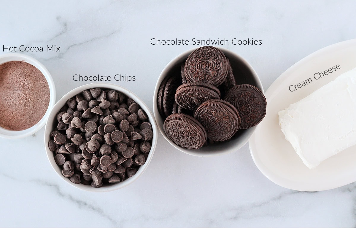 Labeled ingredients for hot cocoa truffles on a white marble countertop.