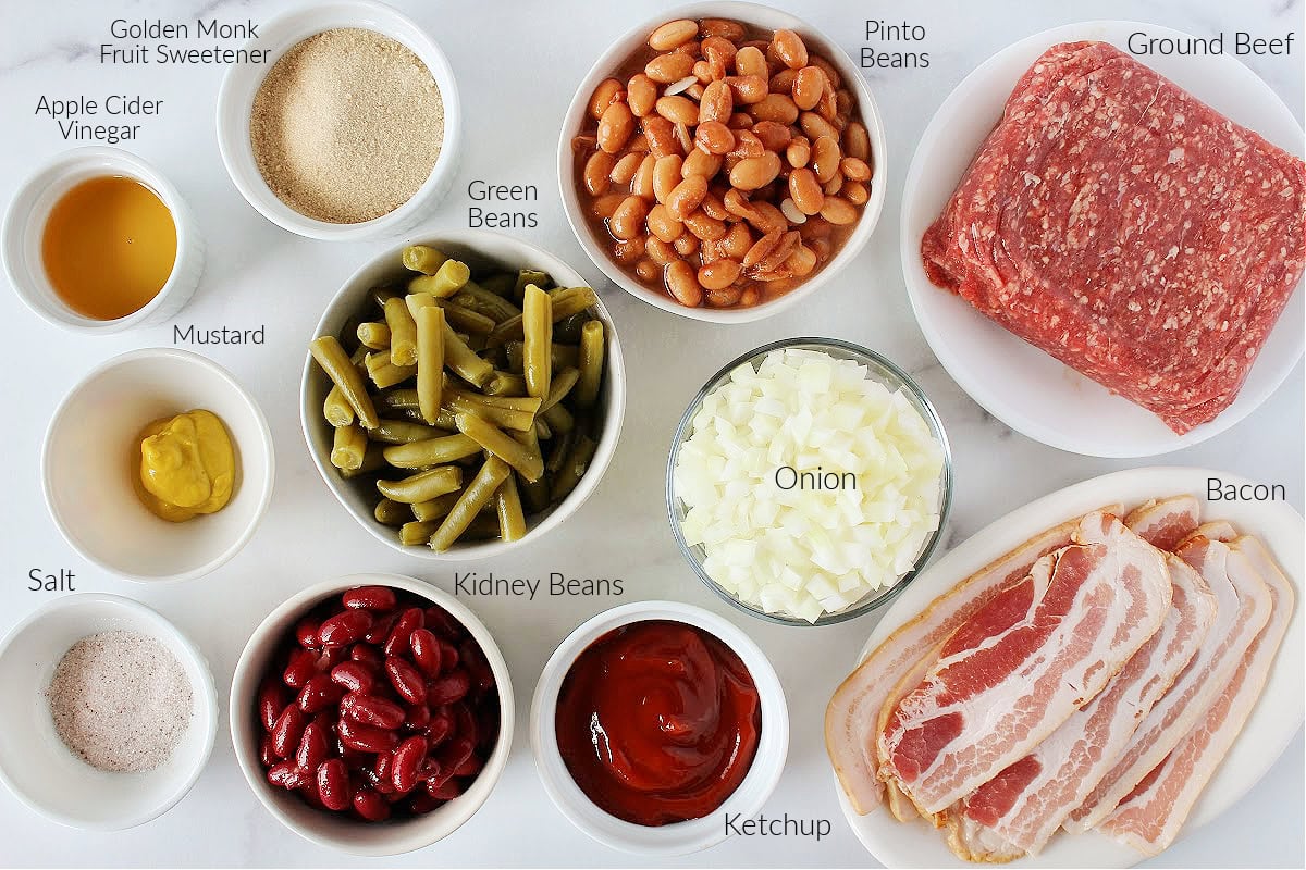 Labeled ingredients for oven baked calico beans on a white marble countertop.