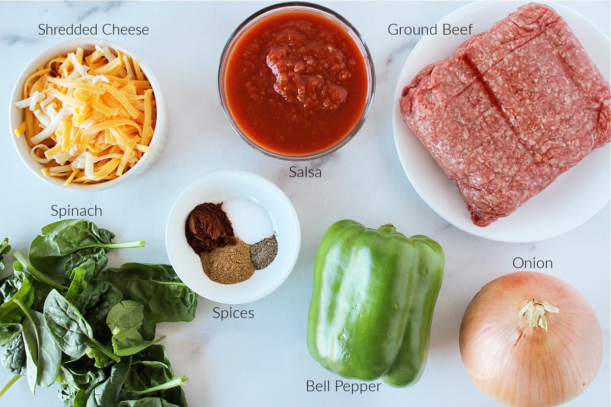 Labeled ingredients for Mexican cornbread casserole on a white marble countertop.