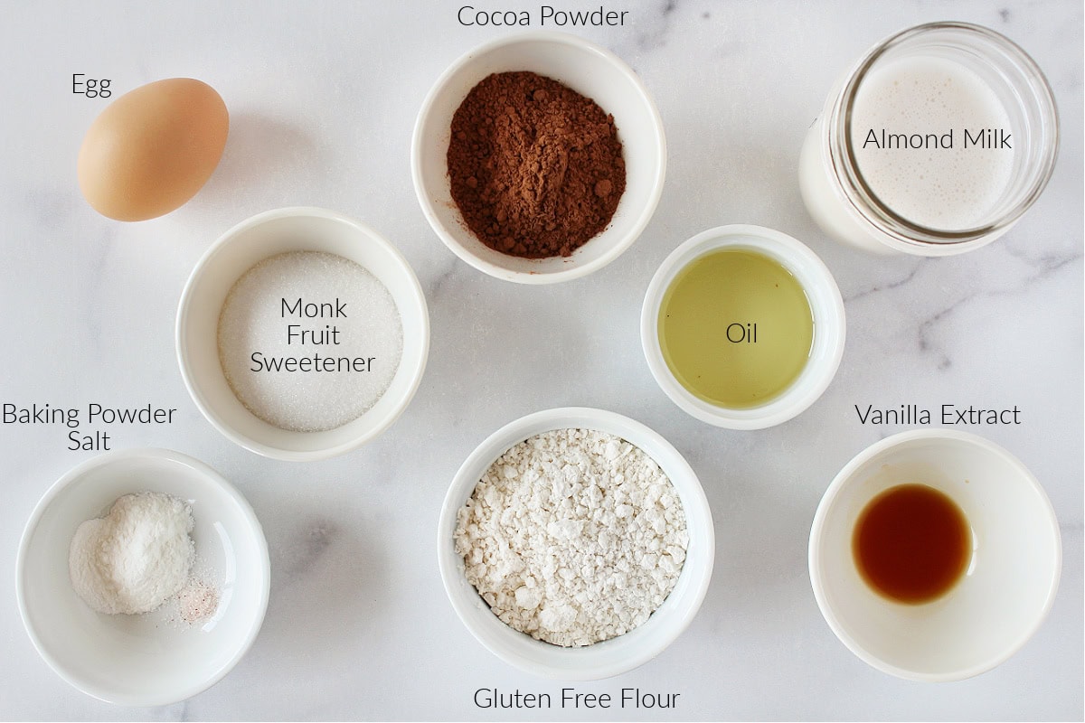 Labeled ingredients for gluten free chocolate waffles on a white marble countertop.