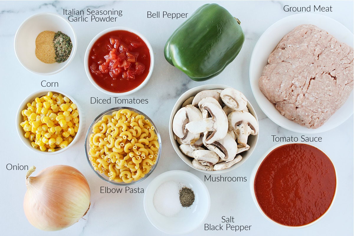 Labeled ingredients for healthy American goulash on a white marble countertop.