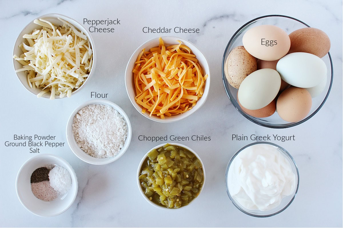 Labeled ingredients for cheesy southwest egg bake on a white marble countertop.