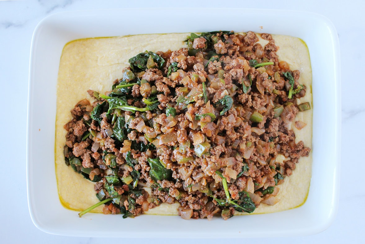 Ground beef mixture over cornbread batter in a 9x13 pan.