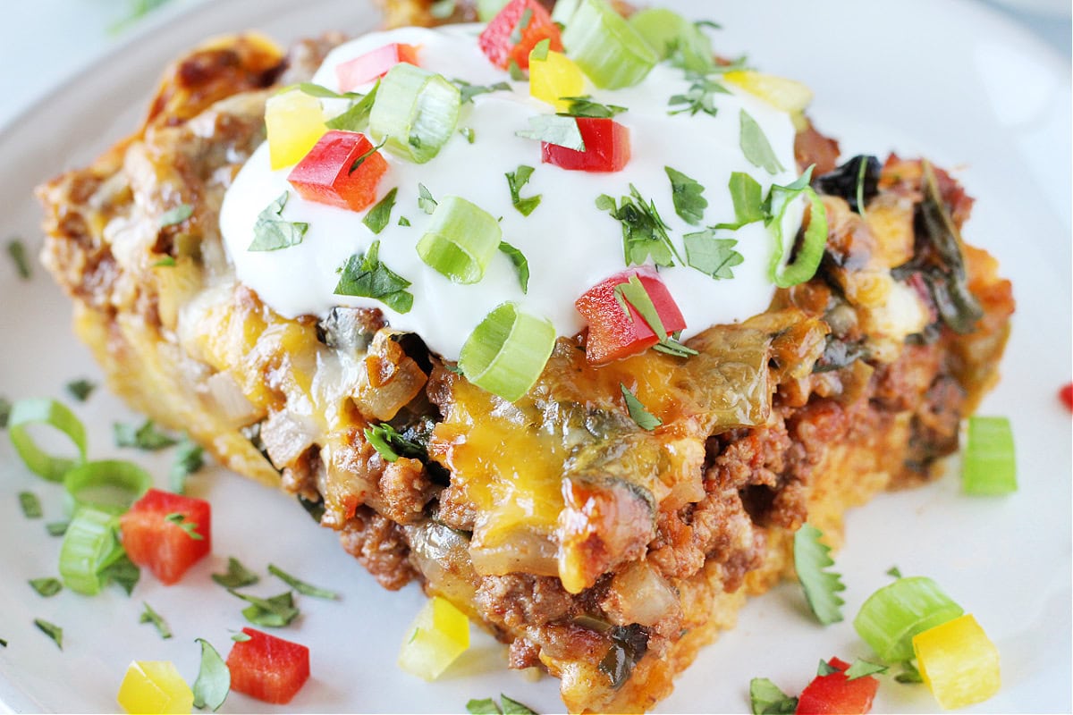 A slice of Mexican cornbread casserole topped with cilantro and green onion.