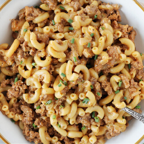 Homemade hamburger helper in a white bowl with vintage spoon.