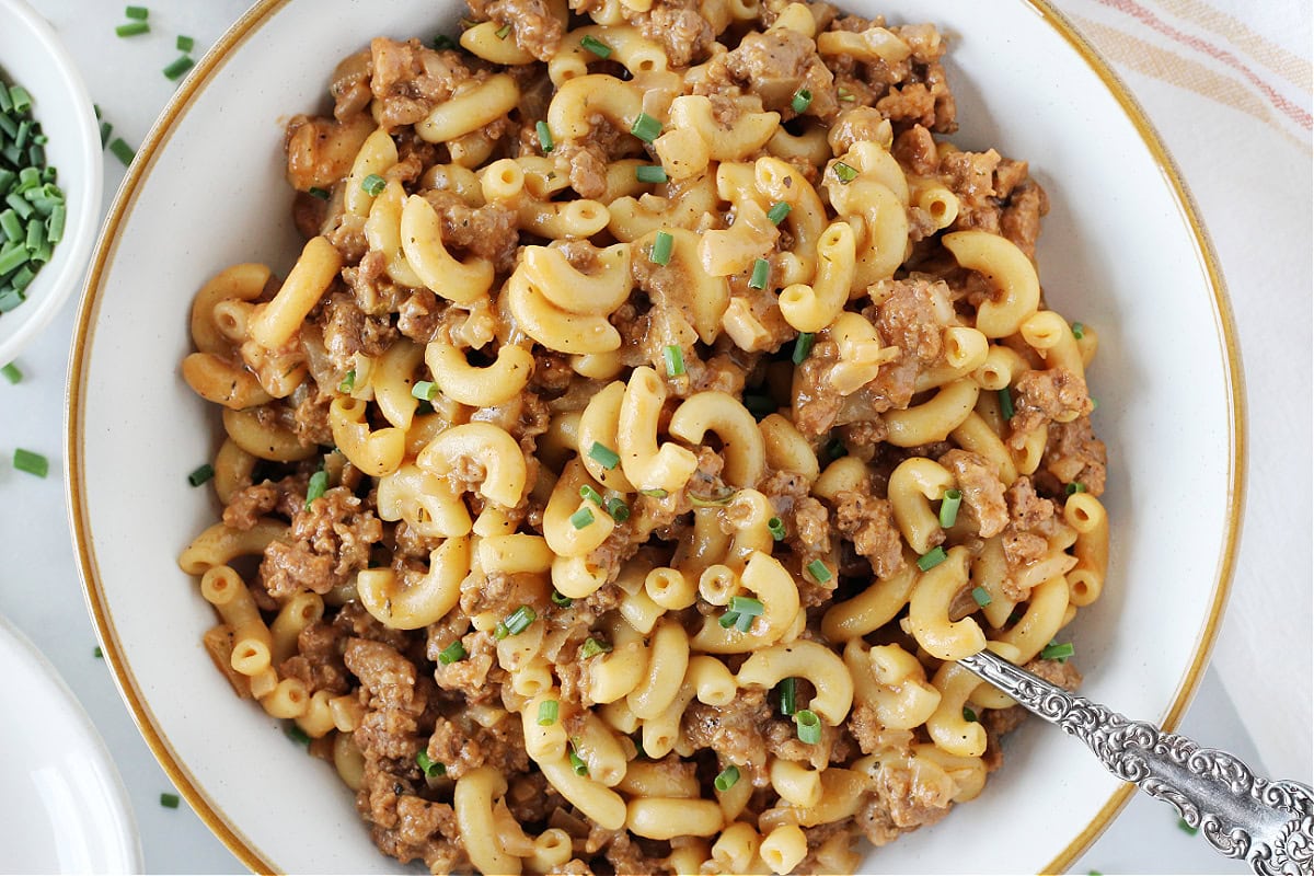 Homemade hamburger helper in a white bowl with vintage spoon.