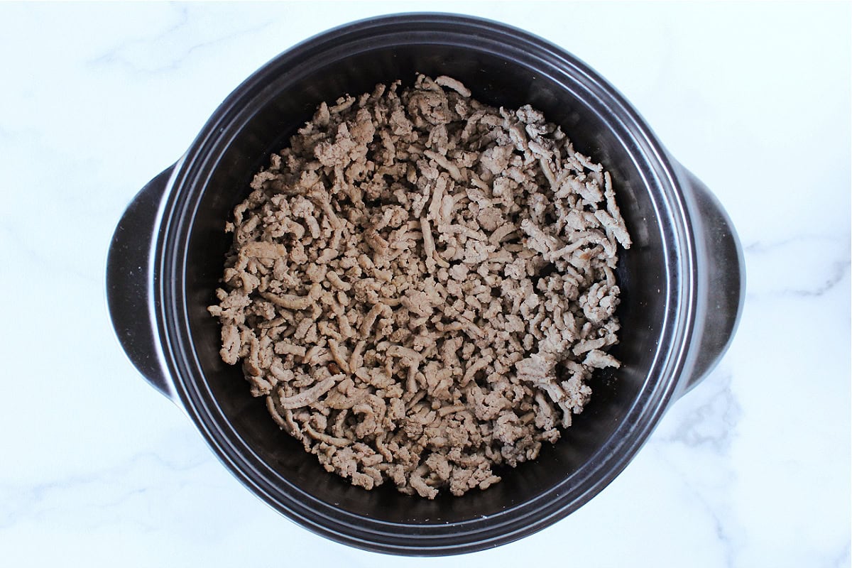 Browned ground turkey in a black soup pot.