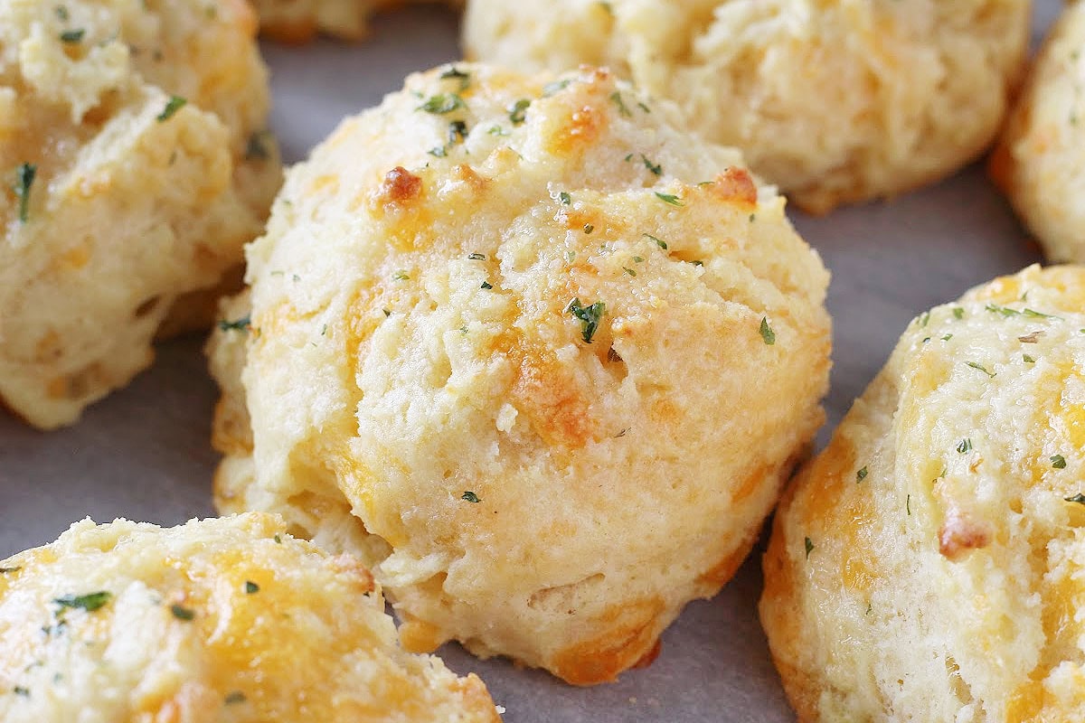 Baked biscuits with garlic and cheese topped with melted butter and parsley.