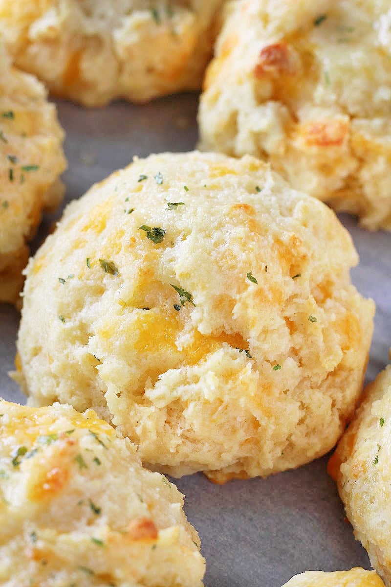 Baked garlic cheddar biscuits on a sheet pan.