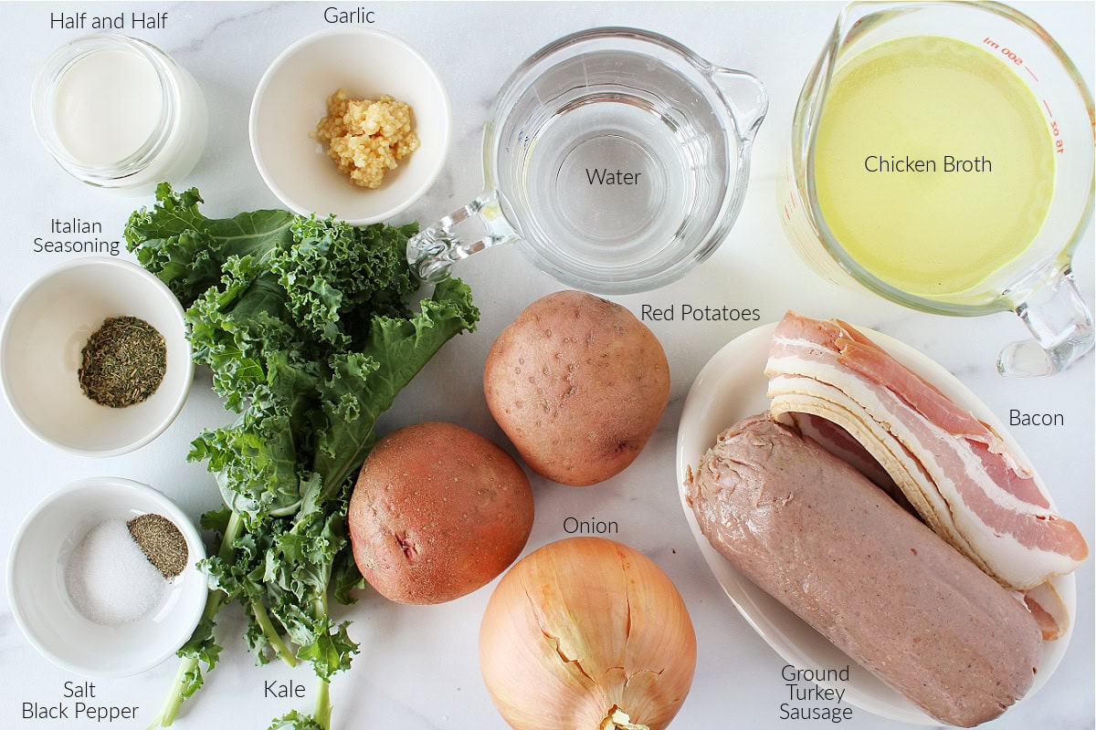 Labeled ingredients for healthy Zuppa Toscana on a white marble countertop.