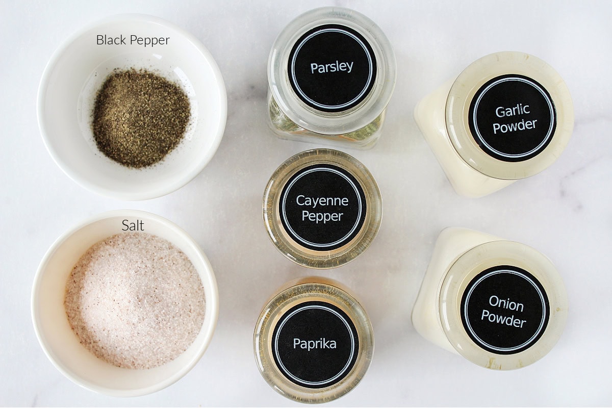 Labeled ingredients for the best burger seasoning on a white marble countertop.