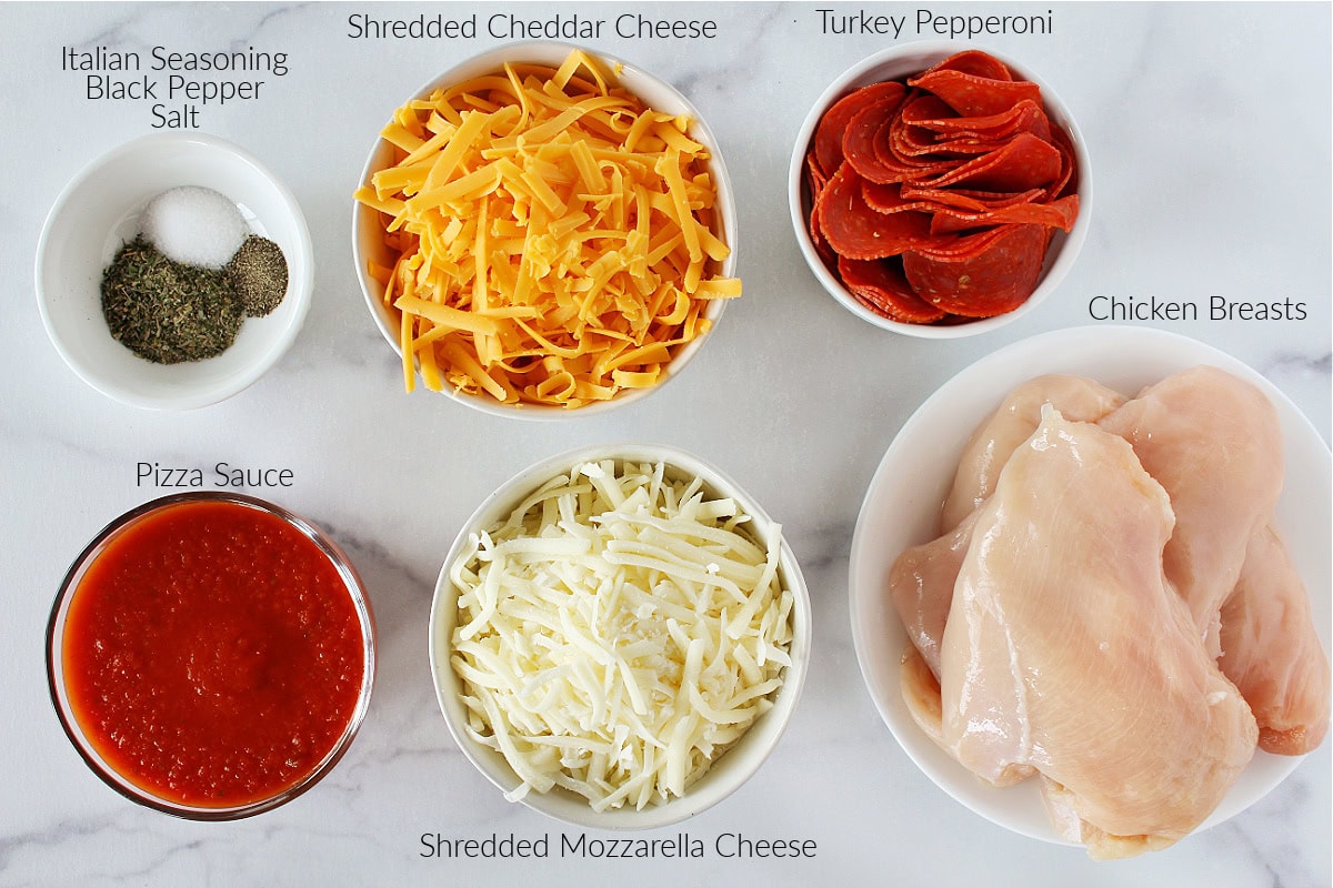 Labeled ingredients for healthy pizza chicken on a white marble countertop.