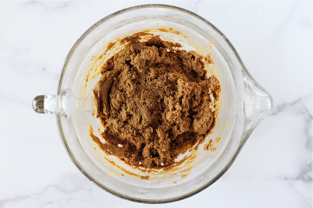 Molasses crinkle cookies batter in a glass bowl.