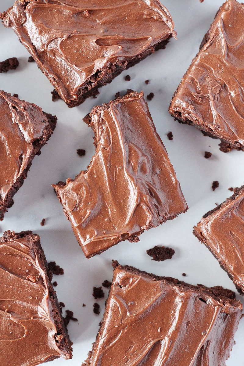 A bite taken out of a brownie with homemade chocolate frosting.