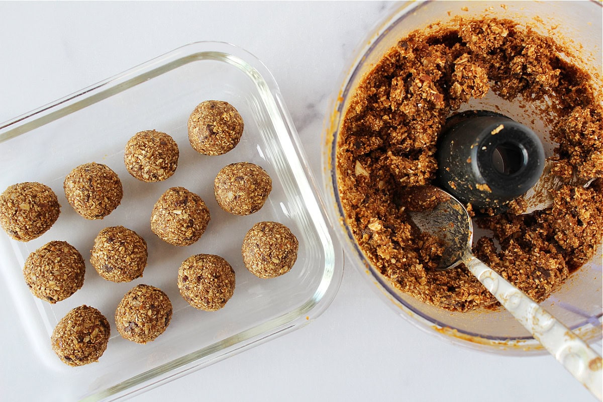 Chocolate chip pumpkin energy balls in a glass container and the batter with a spoon.