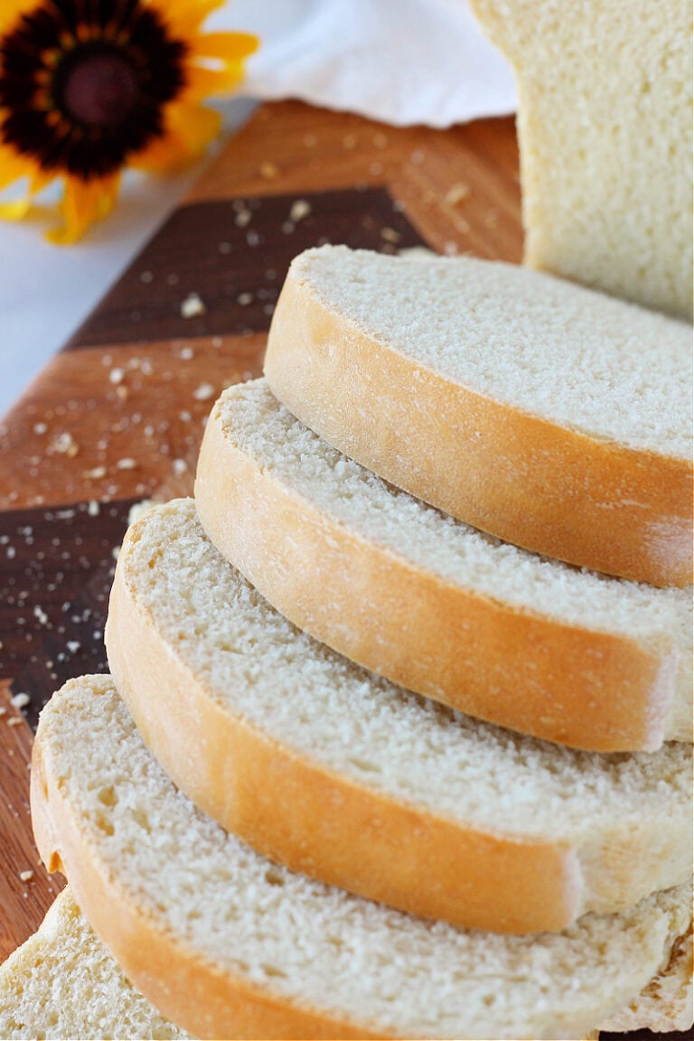 Discard sourdough sandwich bread slices on a wooden cutting board.