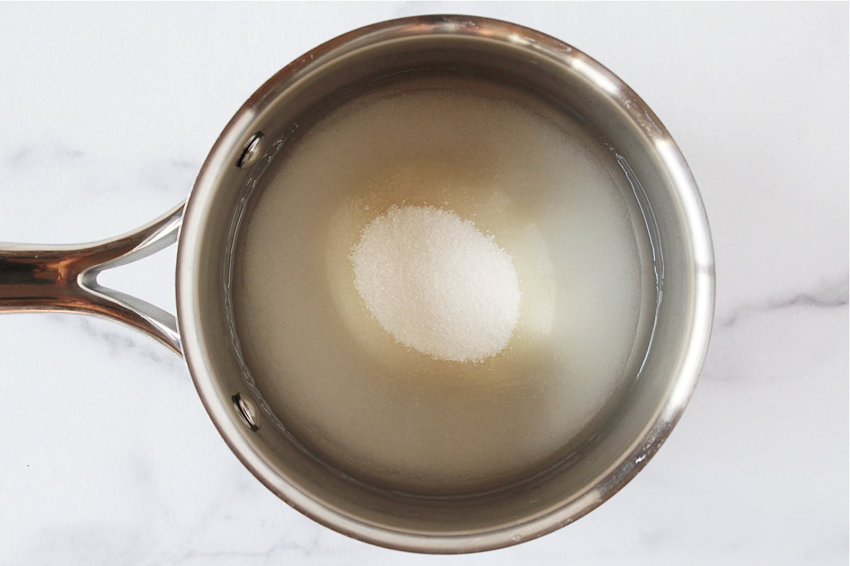 Water and granulated sugar in a small metal soup pot.