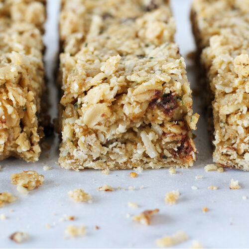 Three homemade granola bars with chocolate chips and shredded coconut.