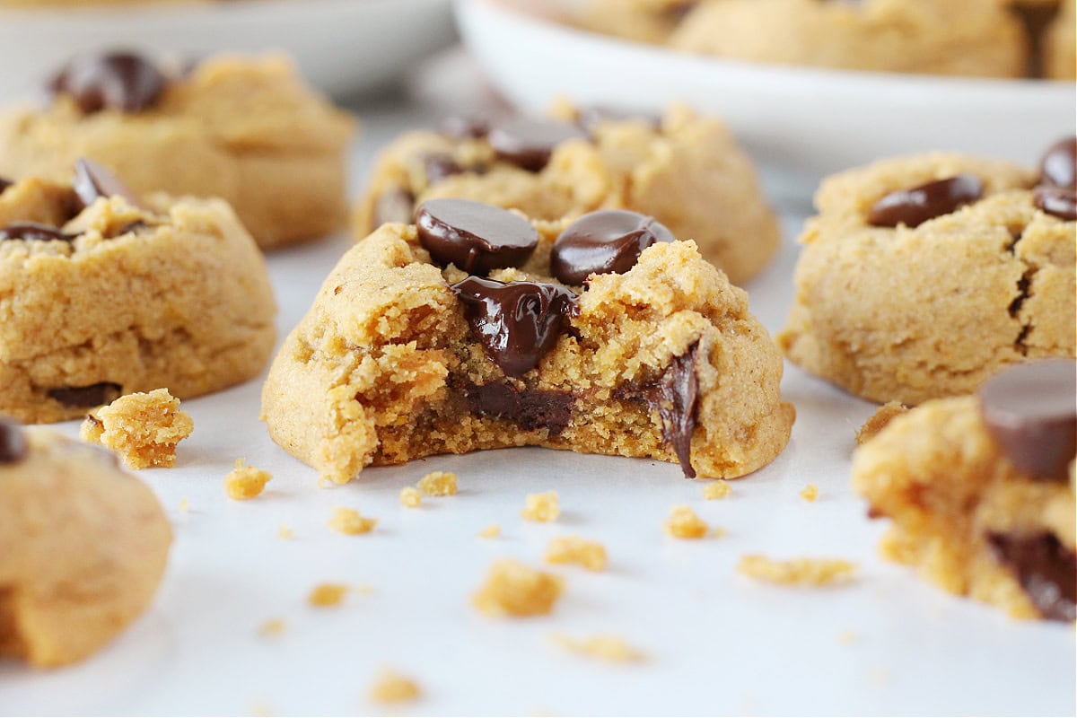 Melted chocolate chips in a pumpkin cookie with a bite taken out.