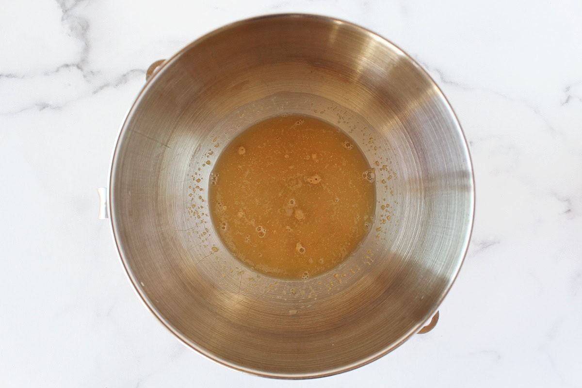 Bubbly yeast in water and honey in a metal bowl.